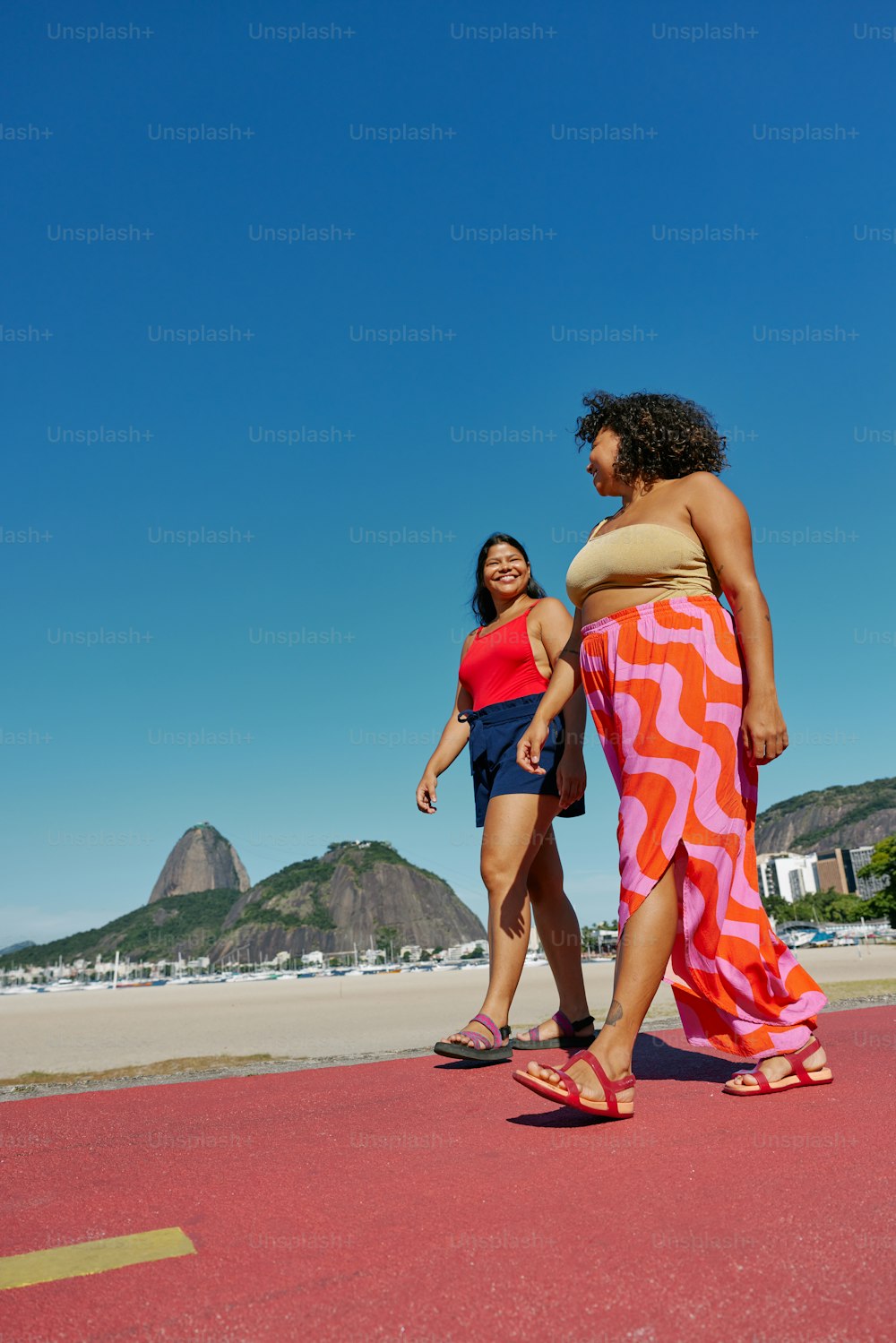 해변을 가로질러 걷고 있는 두 명의 여성