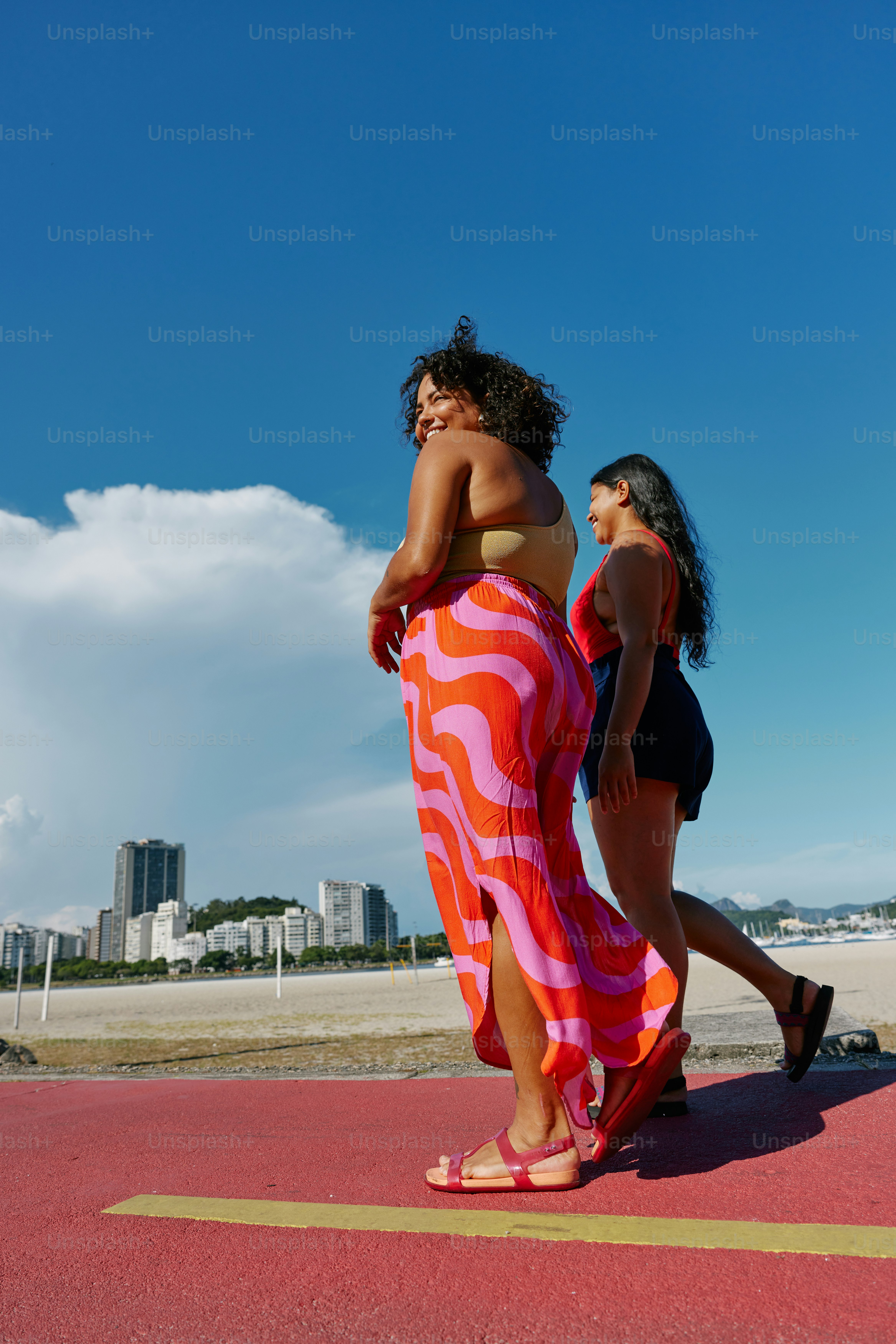 a couple of women walking across a parking lot