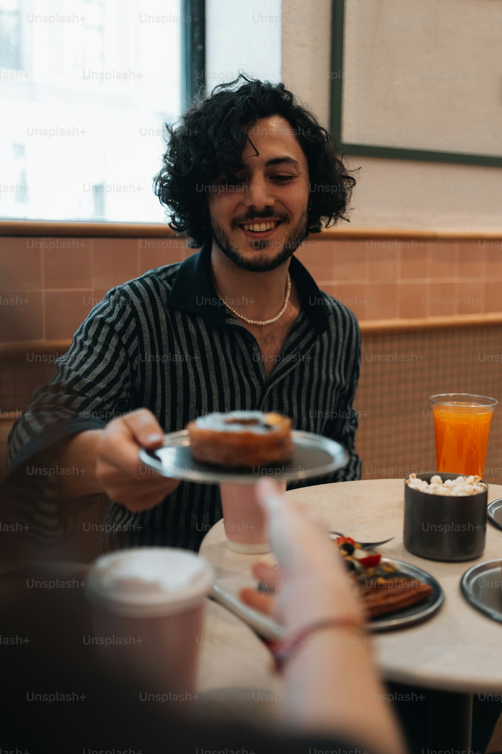 Ein Mann sitzt an einem Tisch mit einem Teller Essen