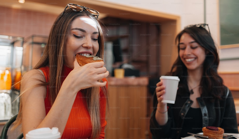 two women sitting at a table eating food