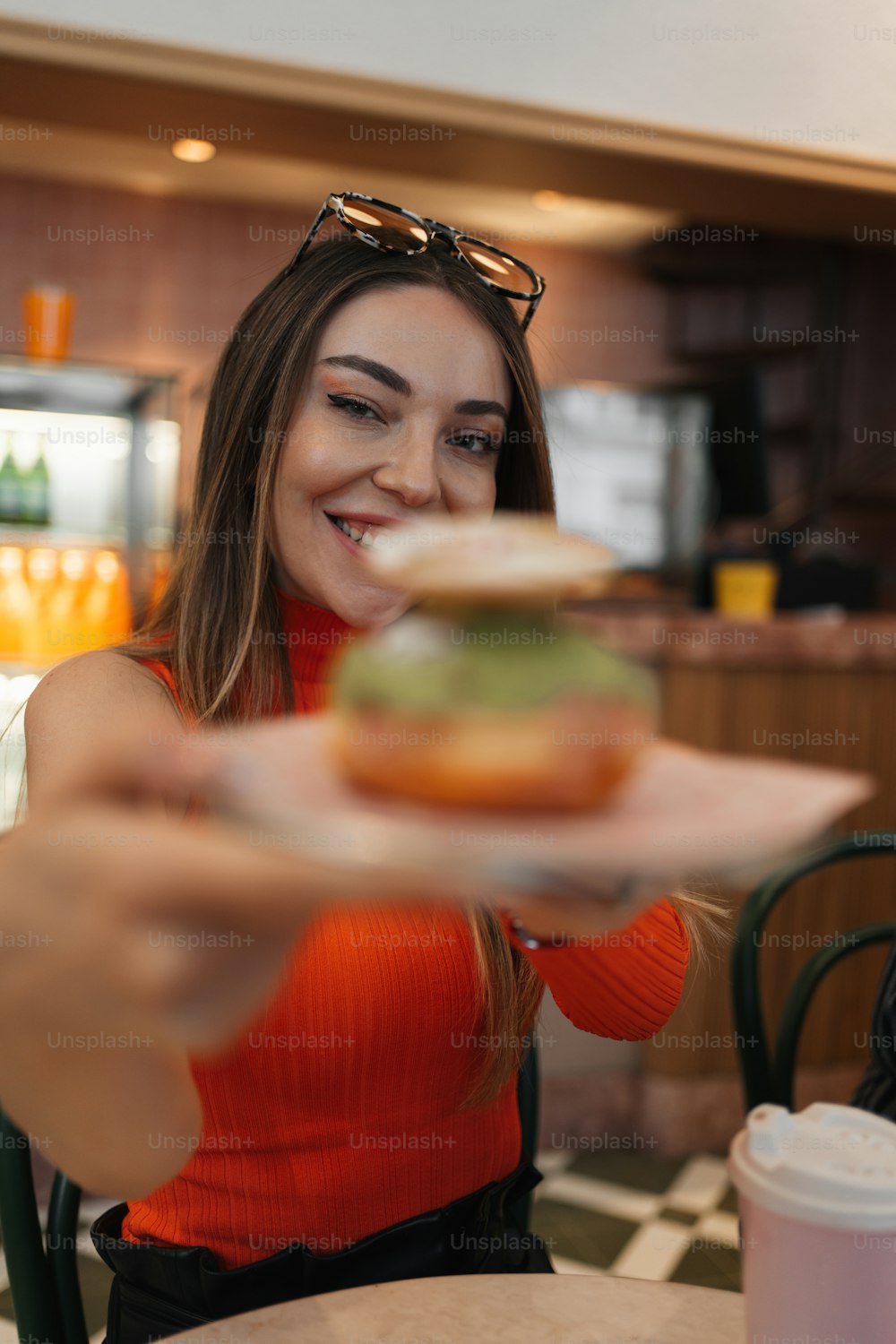 a woman holding a plate with a sandwich on it