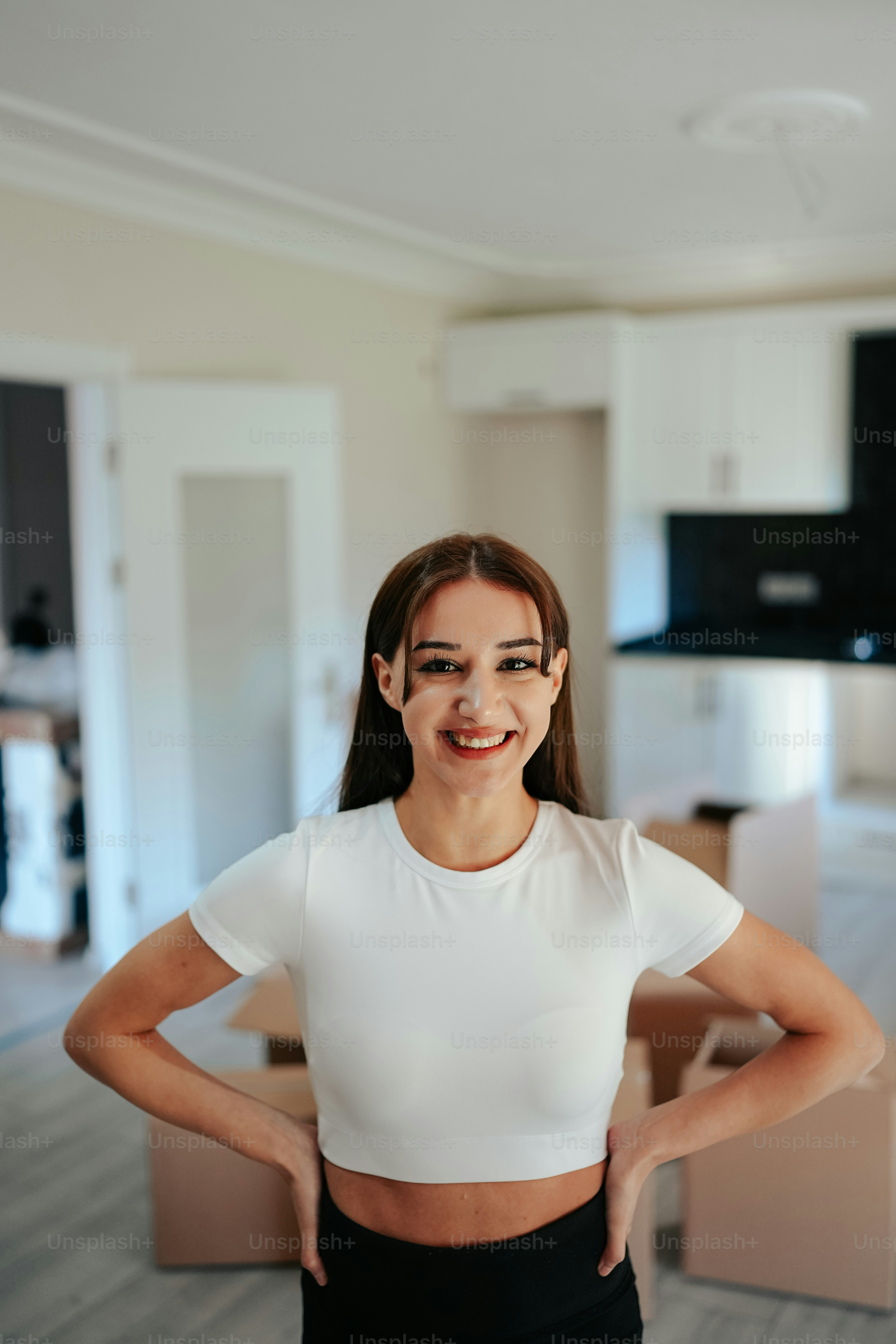 Eine Frau, die in einem Wohnzimmer steht, die Hände in die Hüften gestemmt