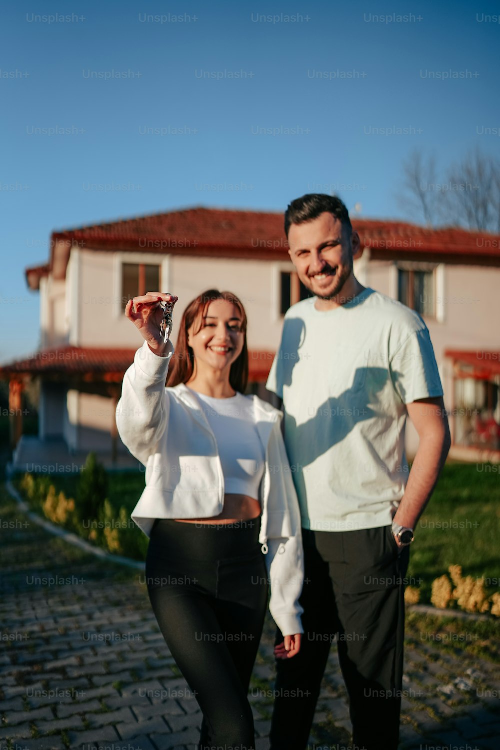 a man and a woman standing in front of a house