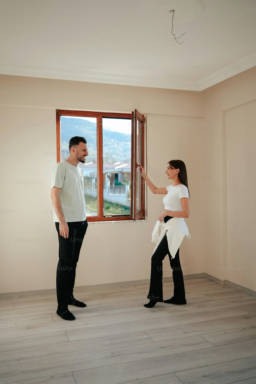 un uomo e una donna in piedi davanti a una finestra