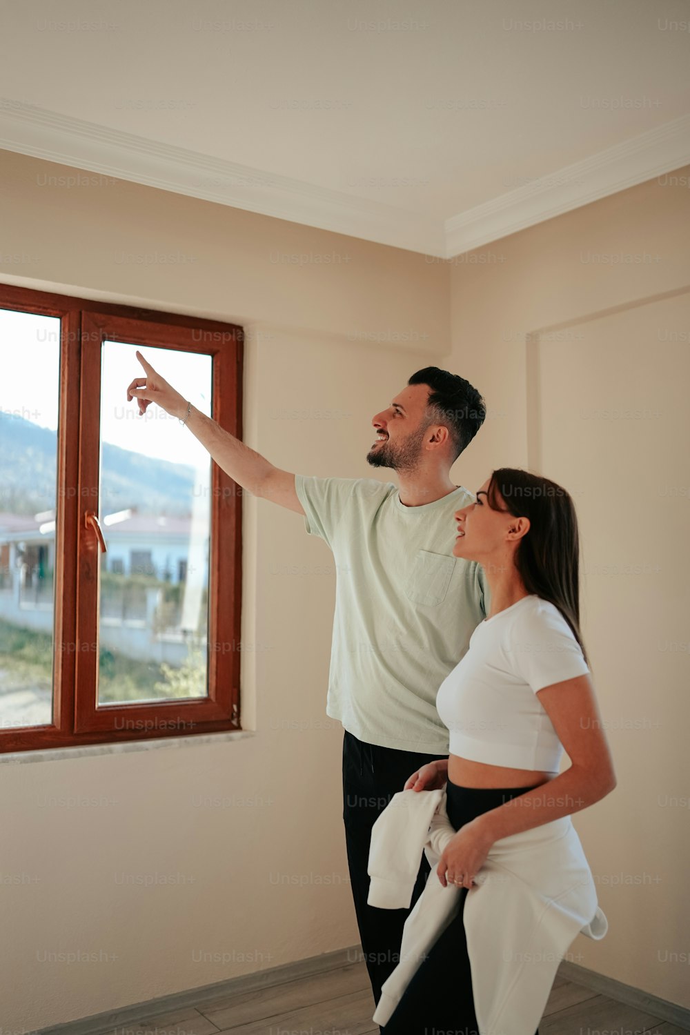 a man and a woman standing in front of a window