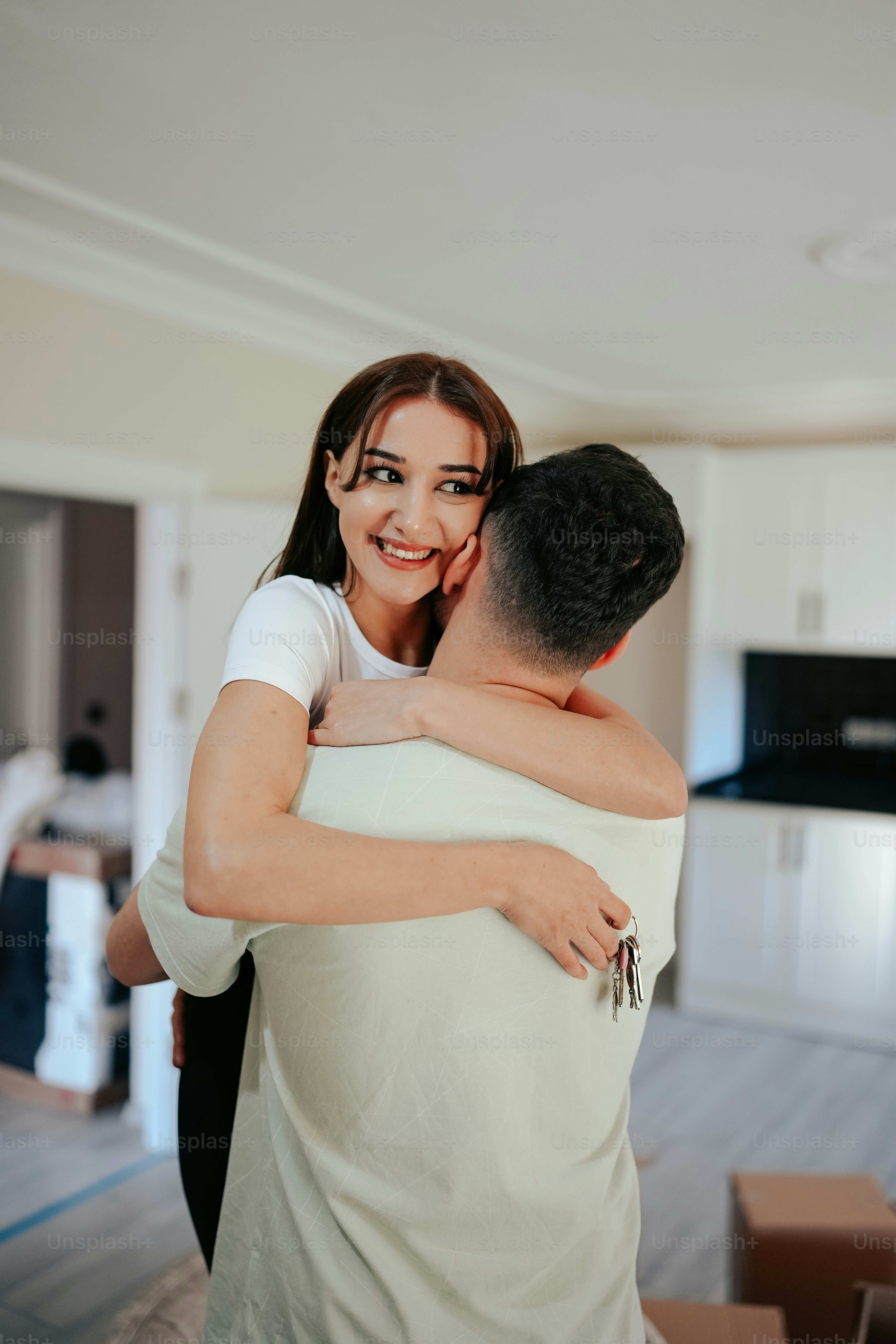 Eine Frau umarmt einen Mann in einem Wohnzimmer