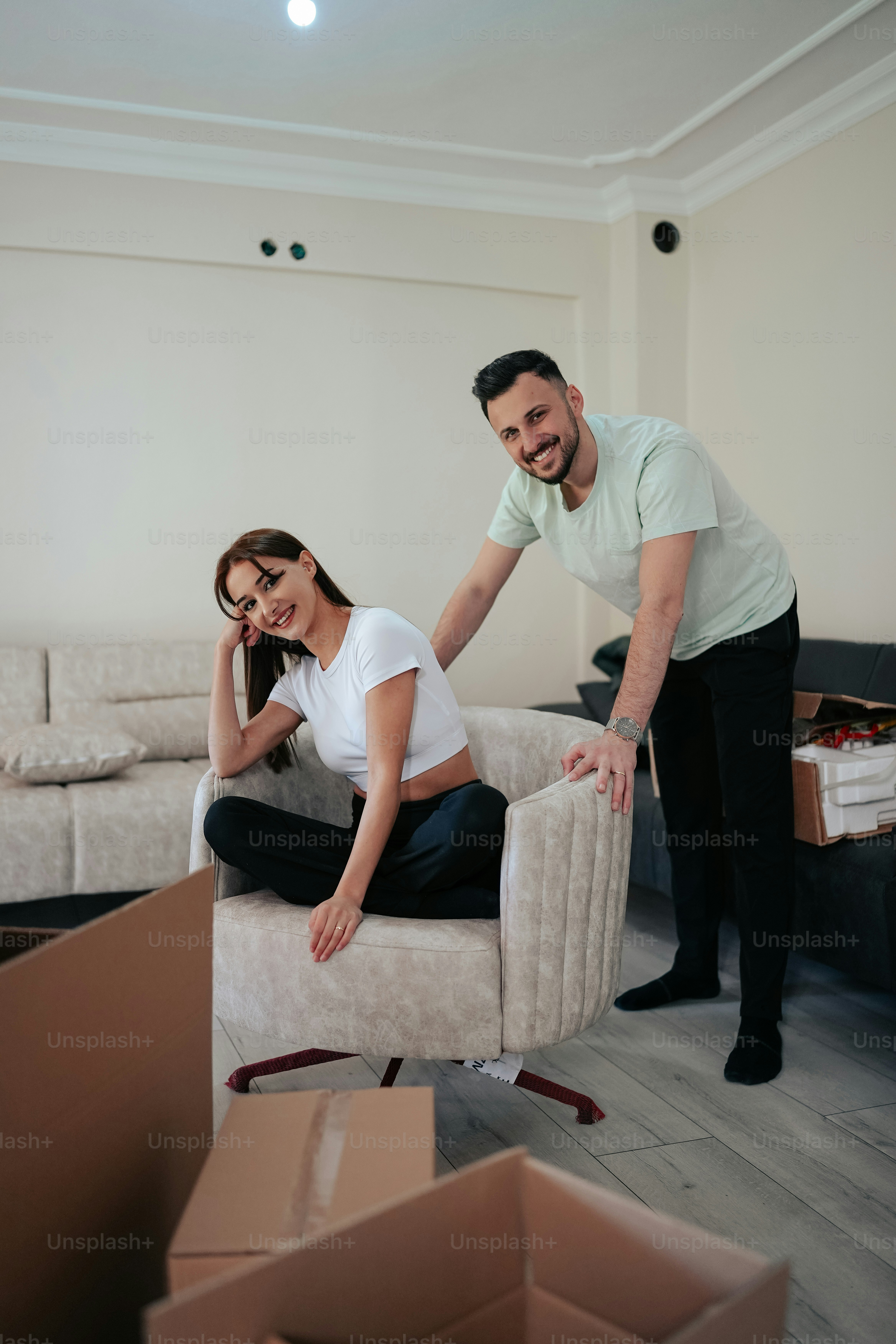 a man standing next to a woman sitting on a chair