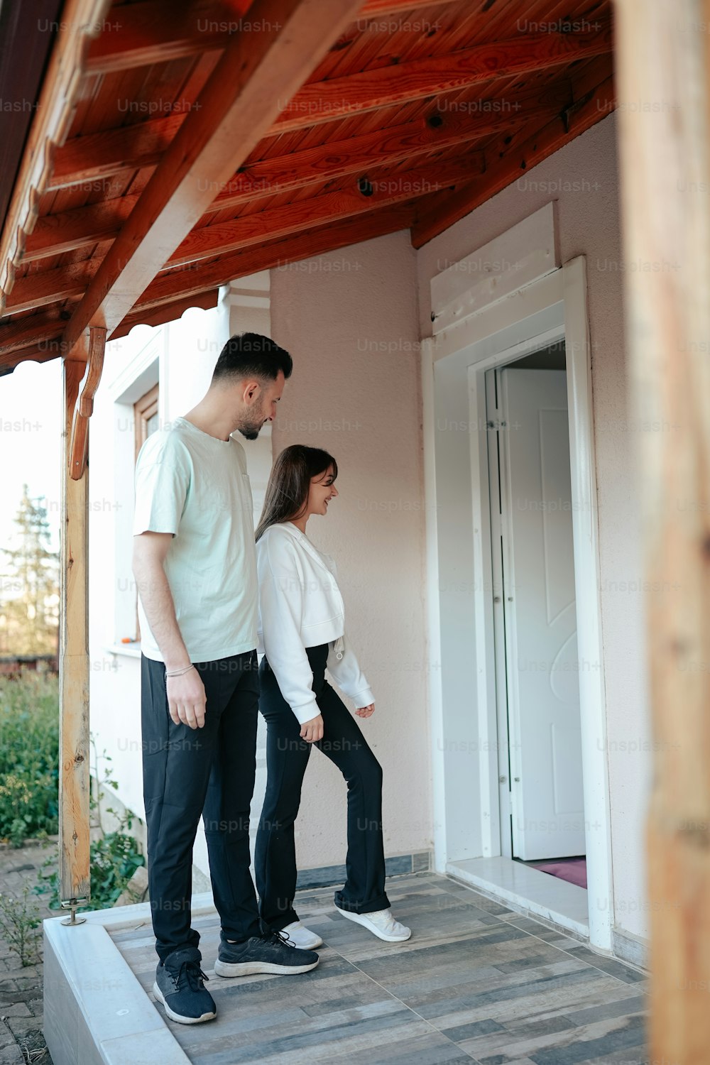 a man and a woman standing on a porch