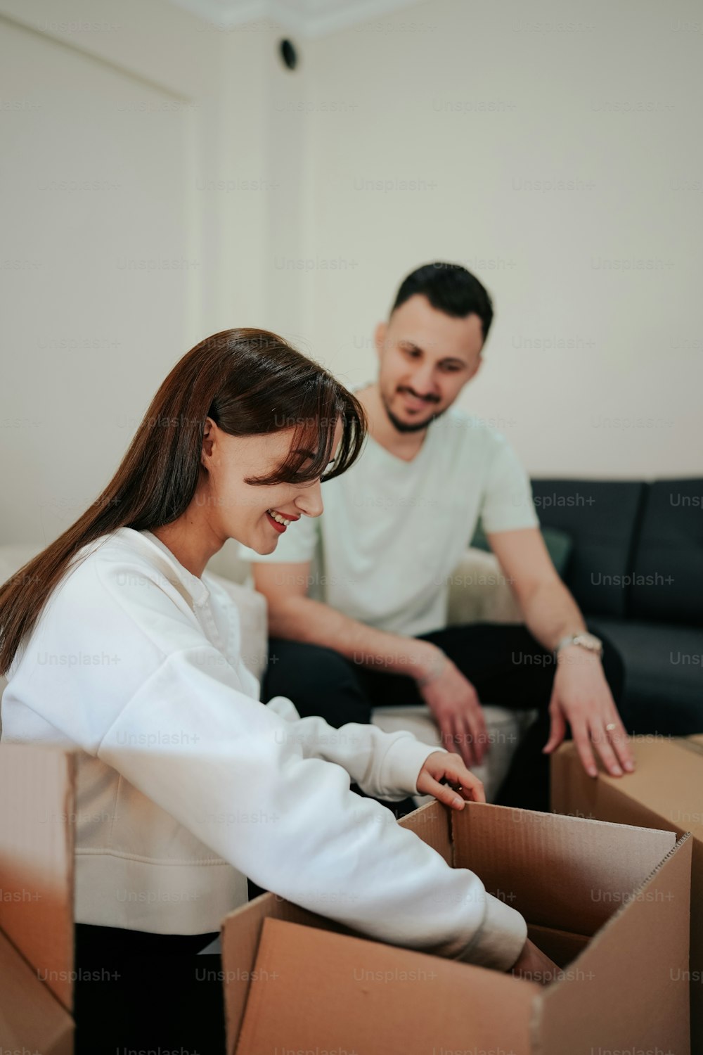 a man and a woman sitting on a couch in a box
