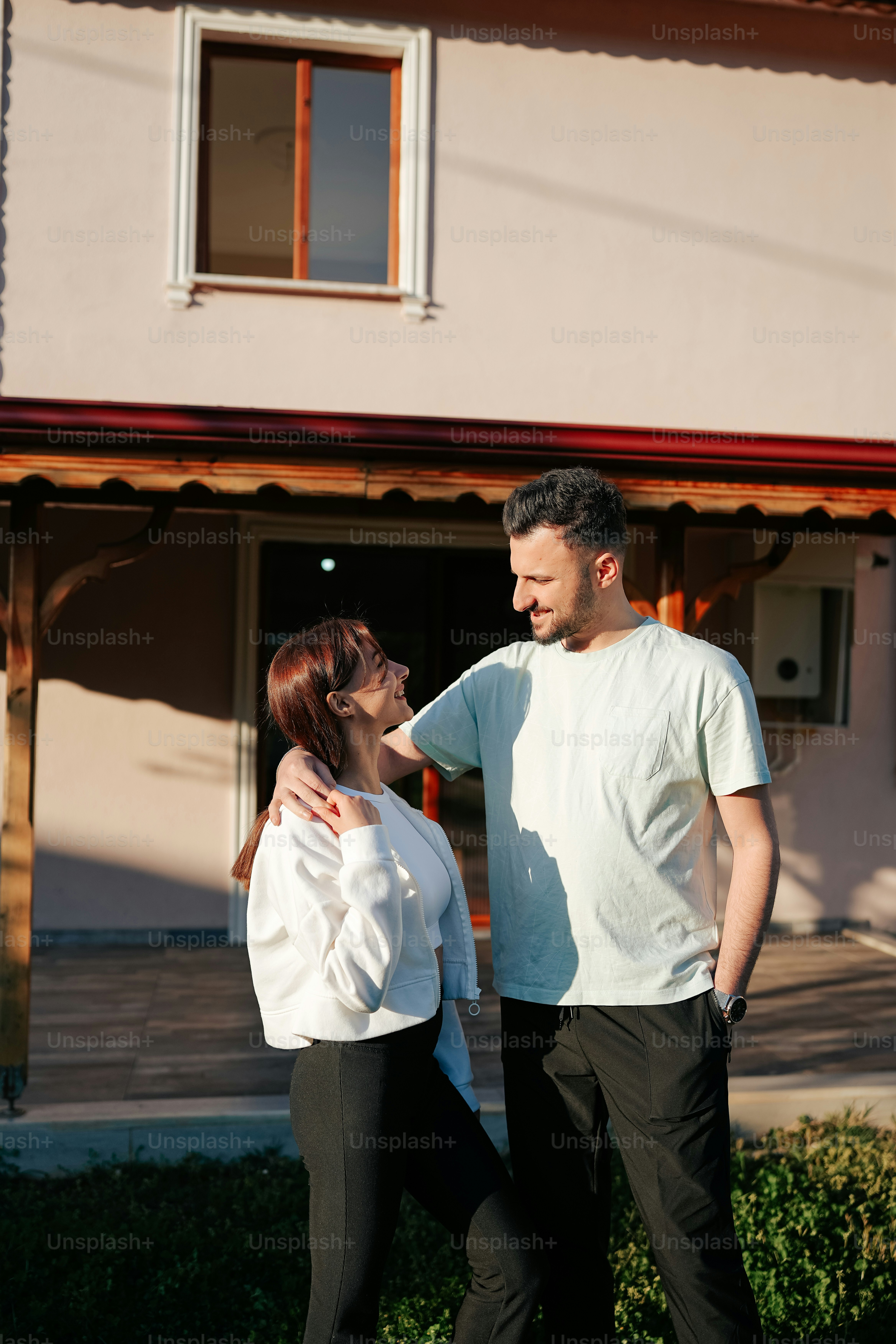 Un hombre parado junto a una mujer frente a una casa foto – Imagen de ...