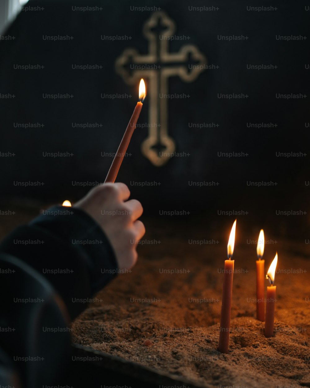 a person holding a pencil in front of a cross