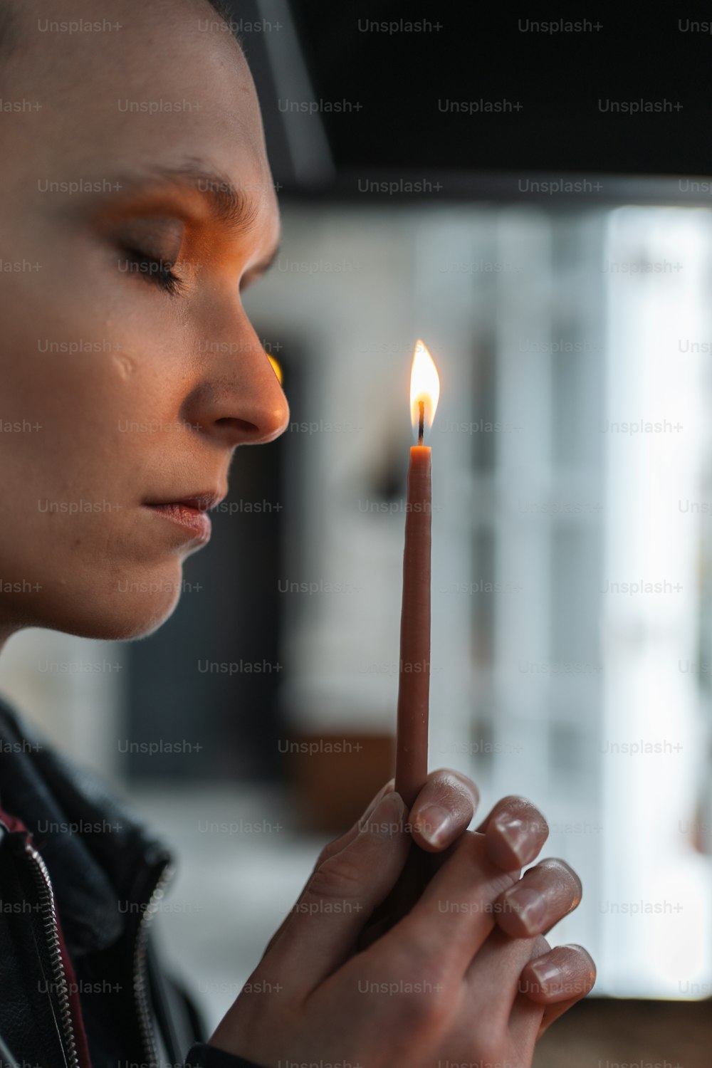 a woman holding a lit candle in her hand