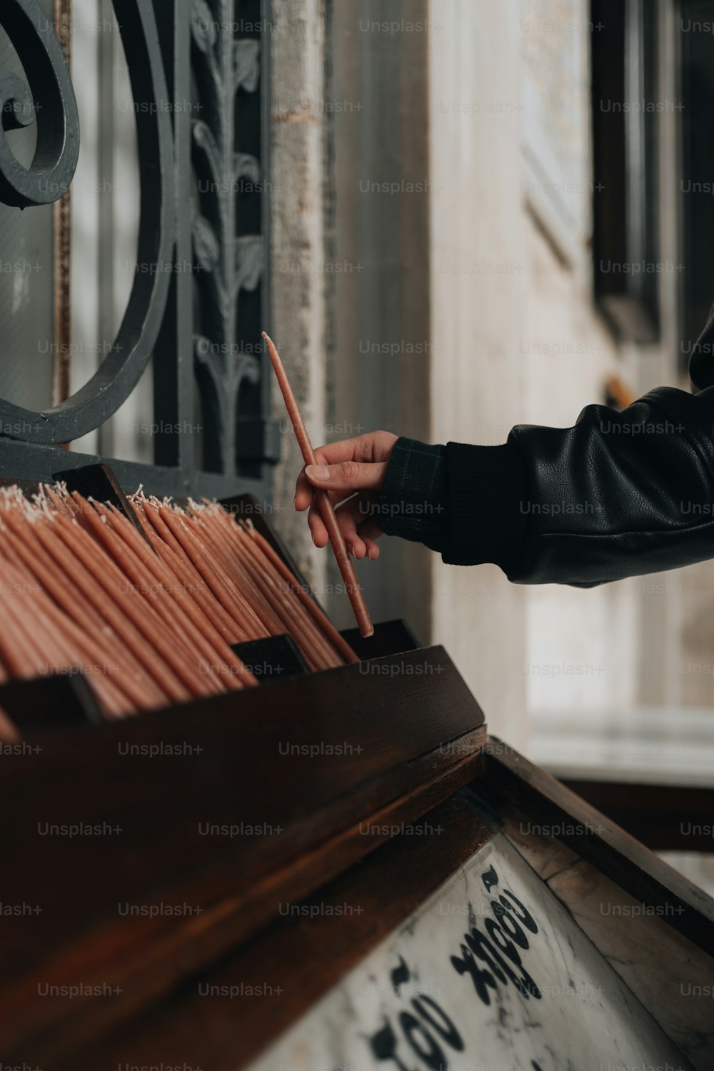 a person holding a pair of chopsticks in front of a box of matches