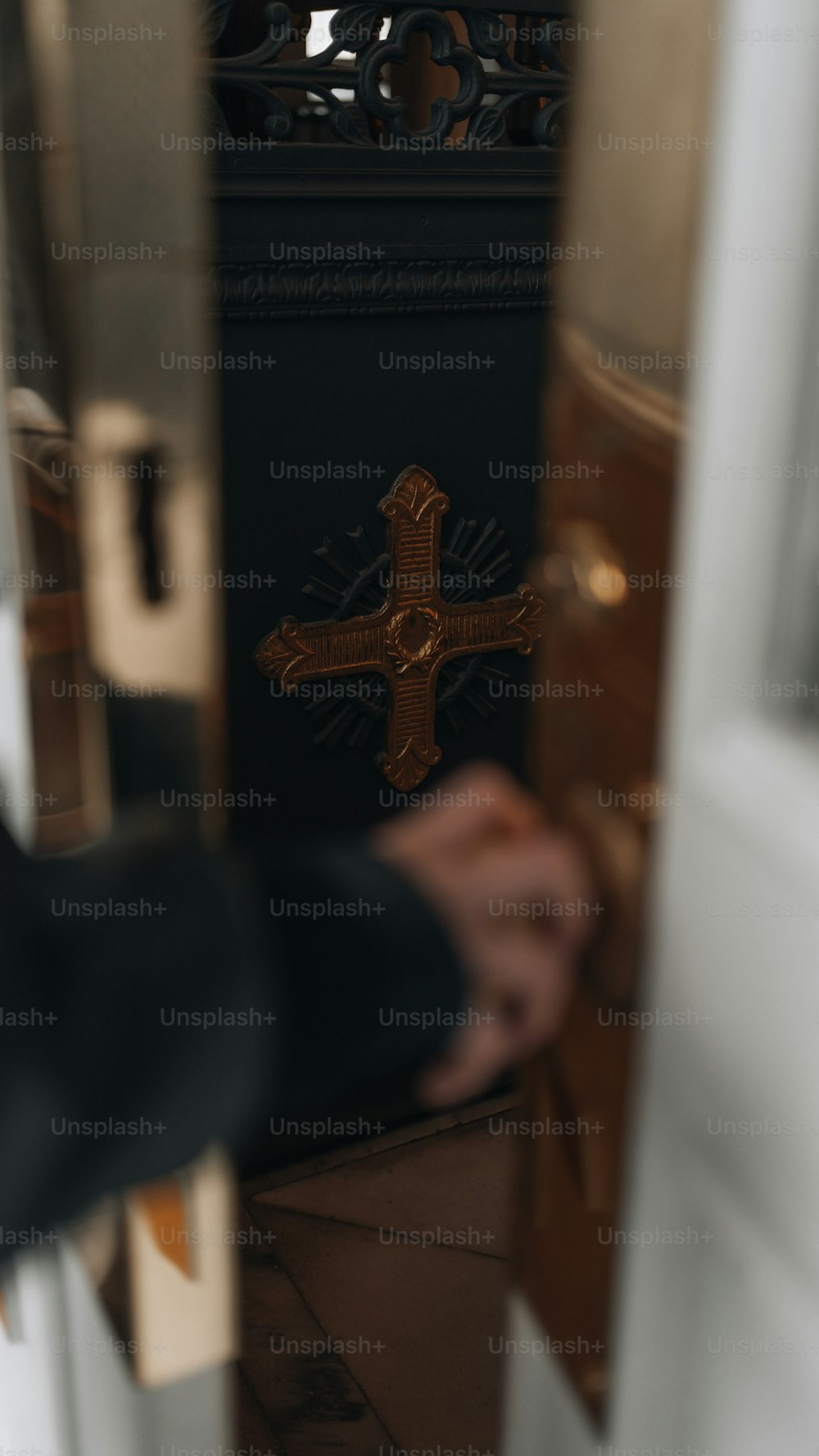 a person holding a cross in front of a door