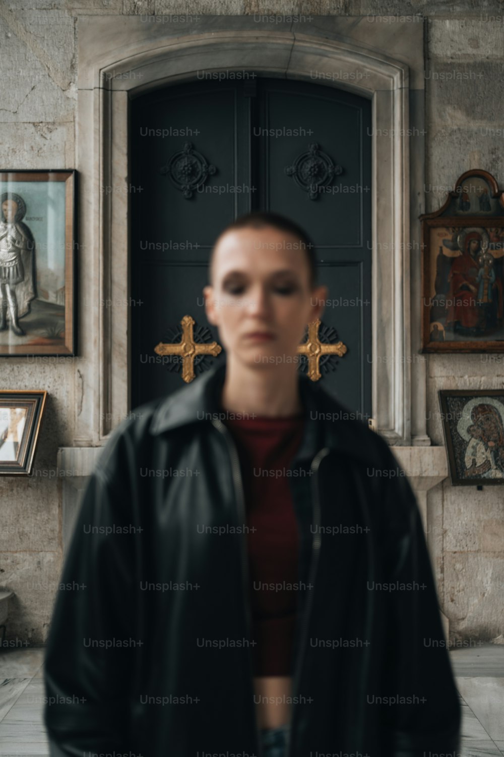 a woman standing in front of a door with a cross on it