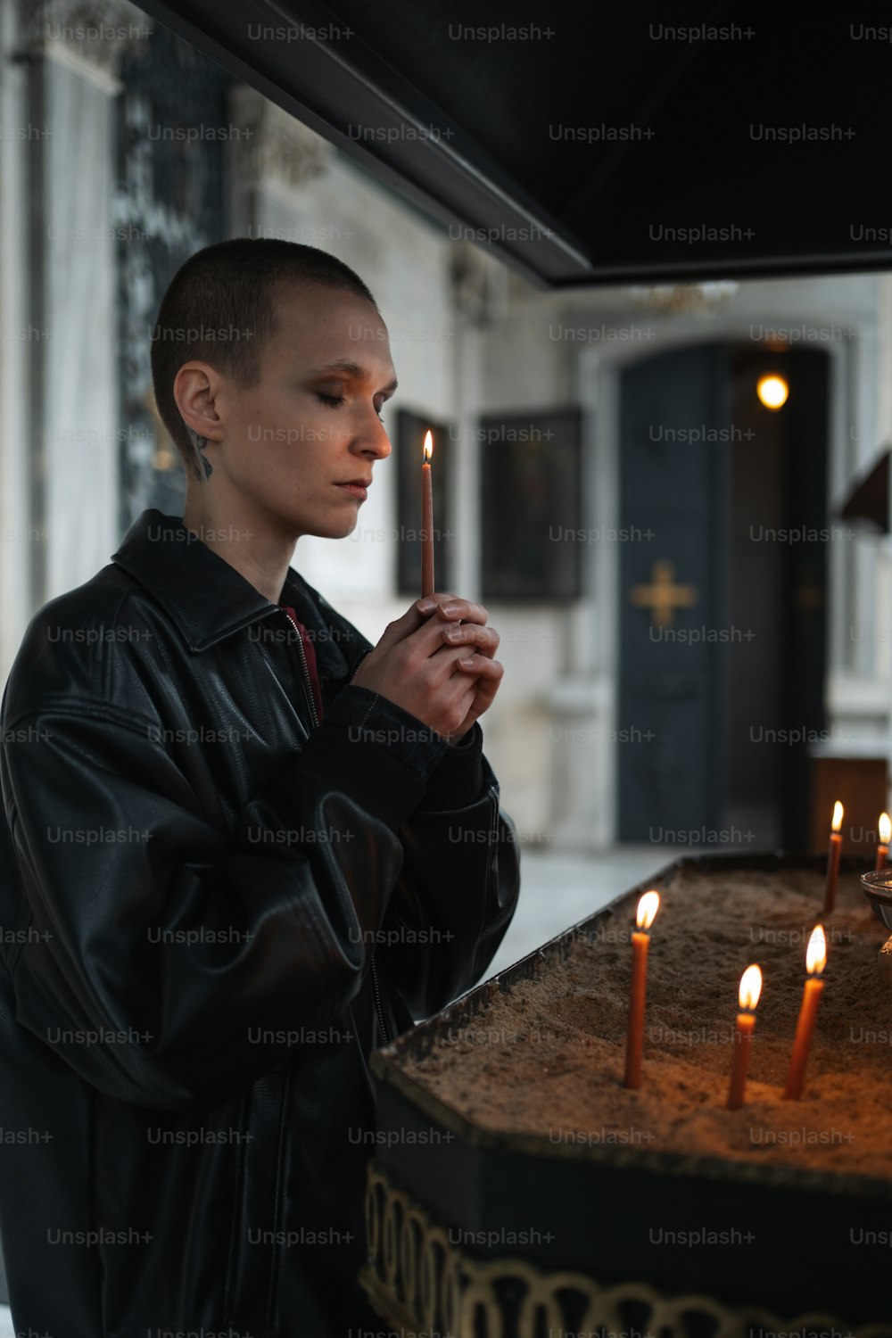 Una mujer sosteniendo una vela frente a un pastel