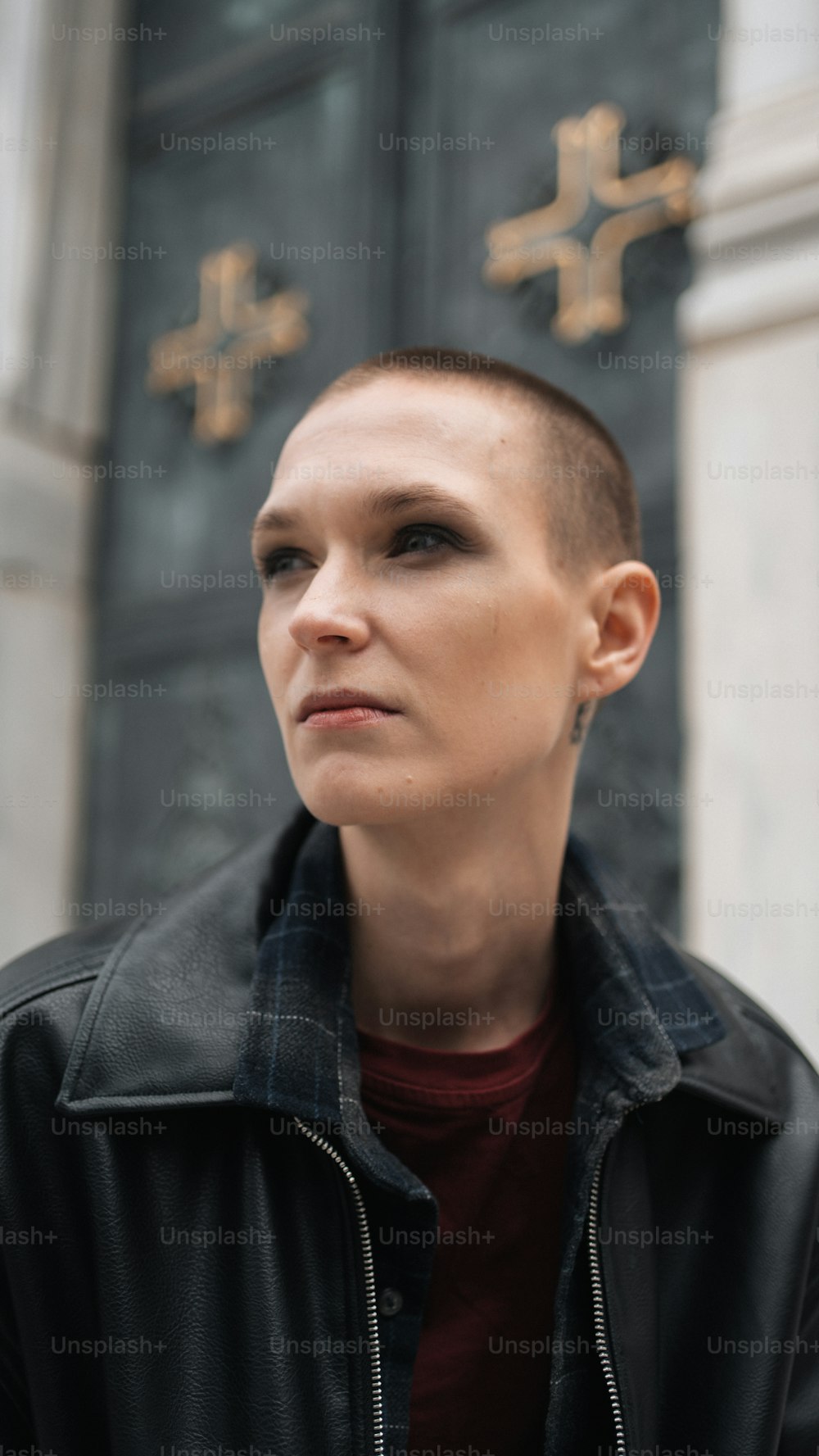 a woman with a shaved head standing in front of a building