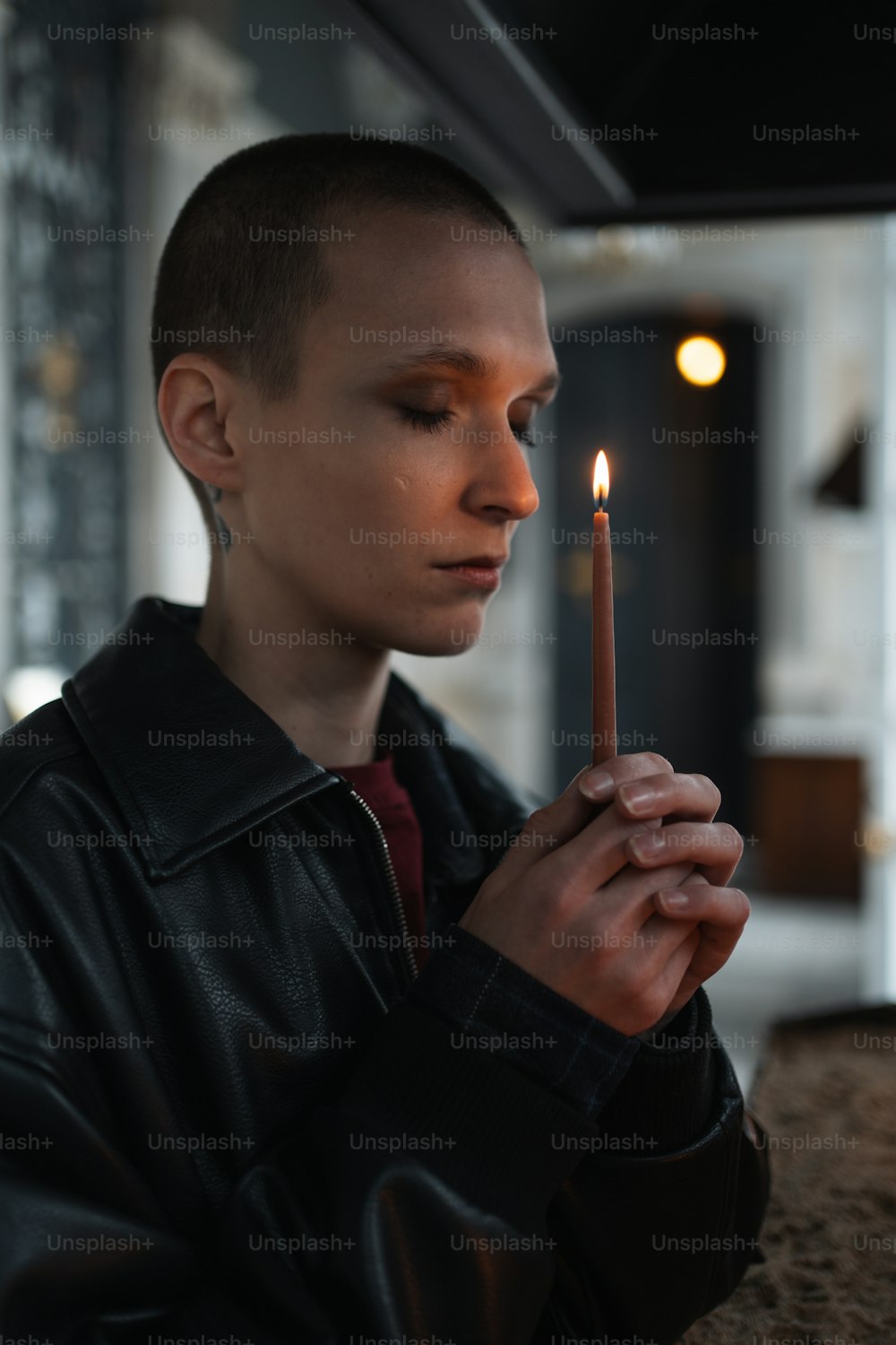 Ein junger Mann, der eine brennende Kerze in der Hand hält