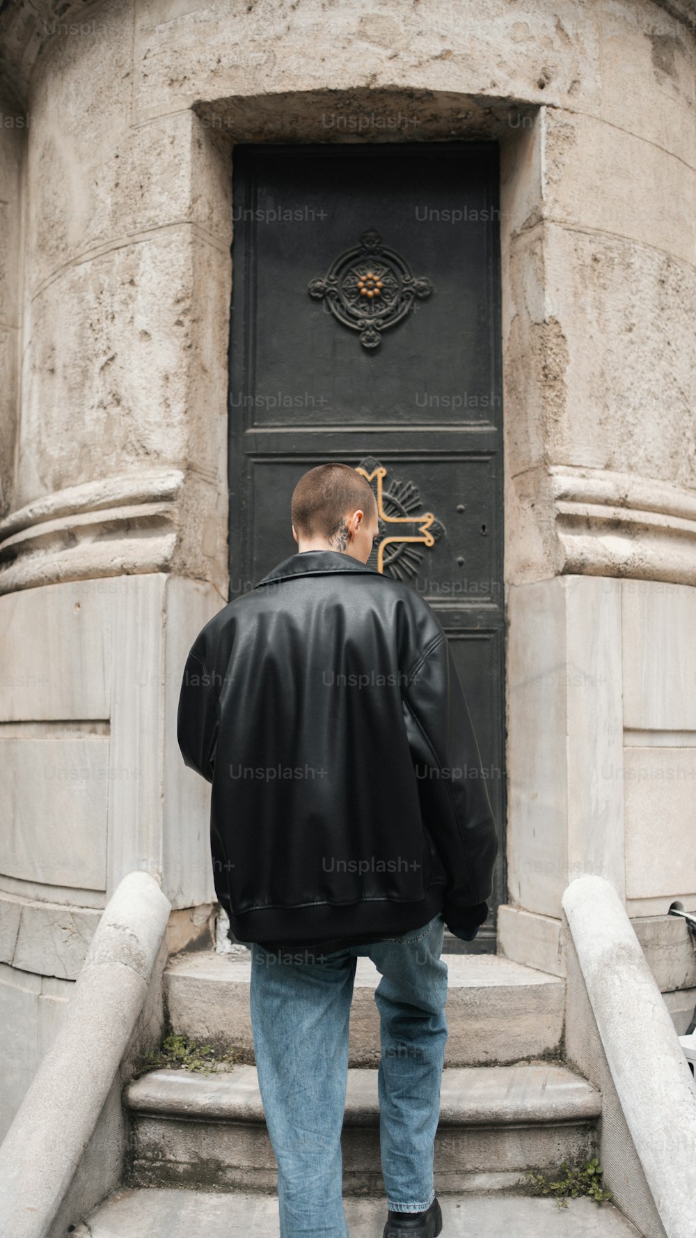 Un homme debout devant une porte noire