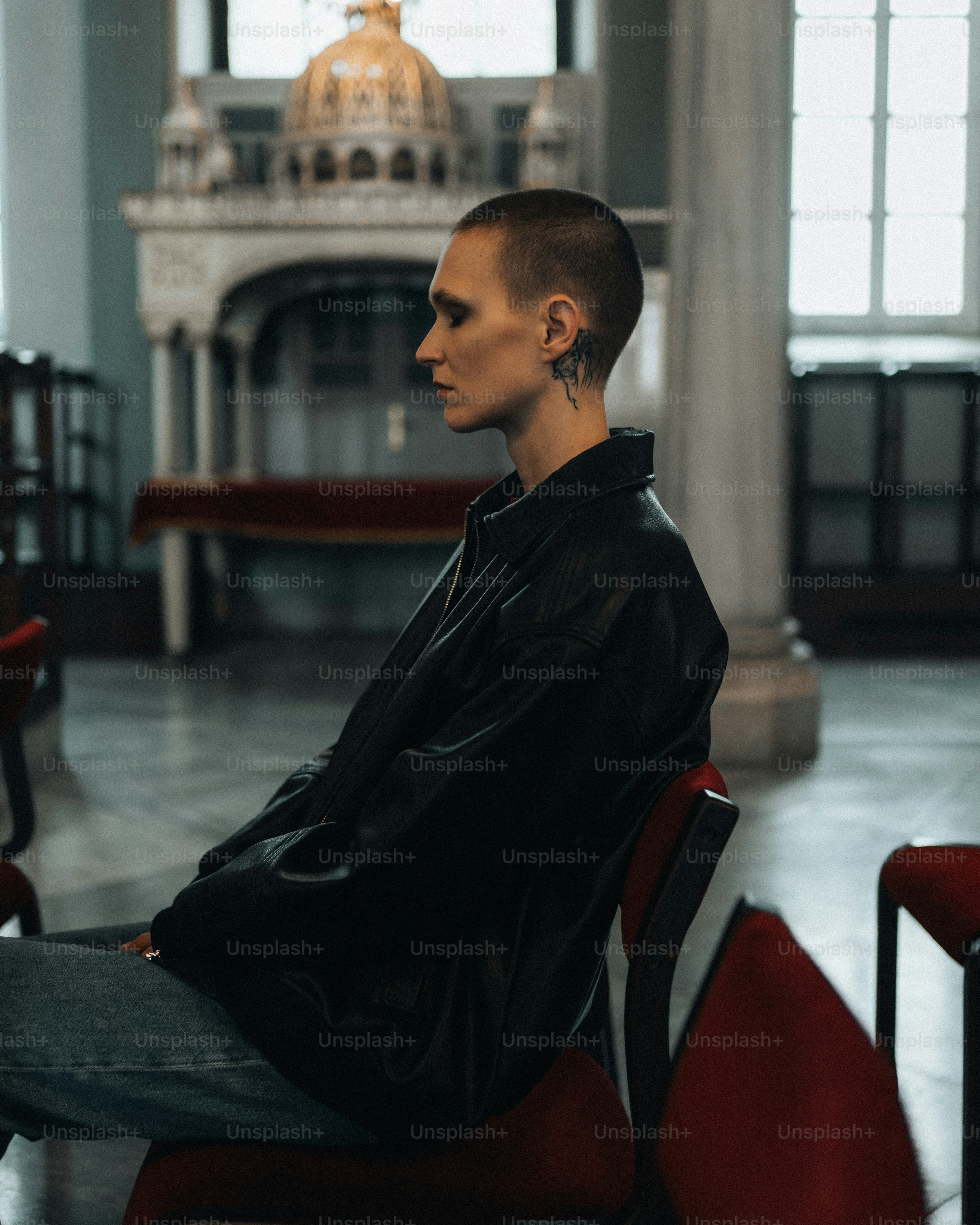 a man sitting on a red chair in a church