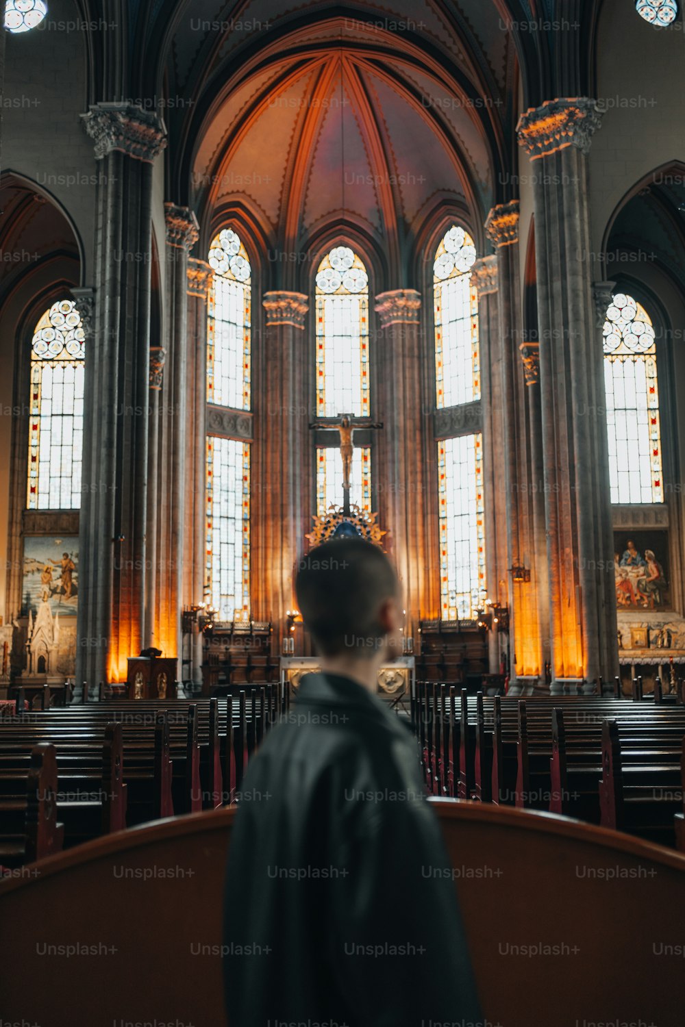 Ein Mann steht vor einer Kirche voller Kirchenbänke
