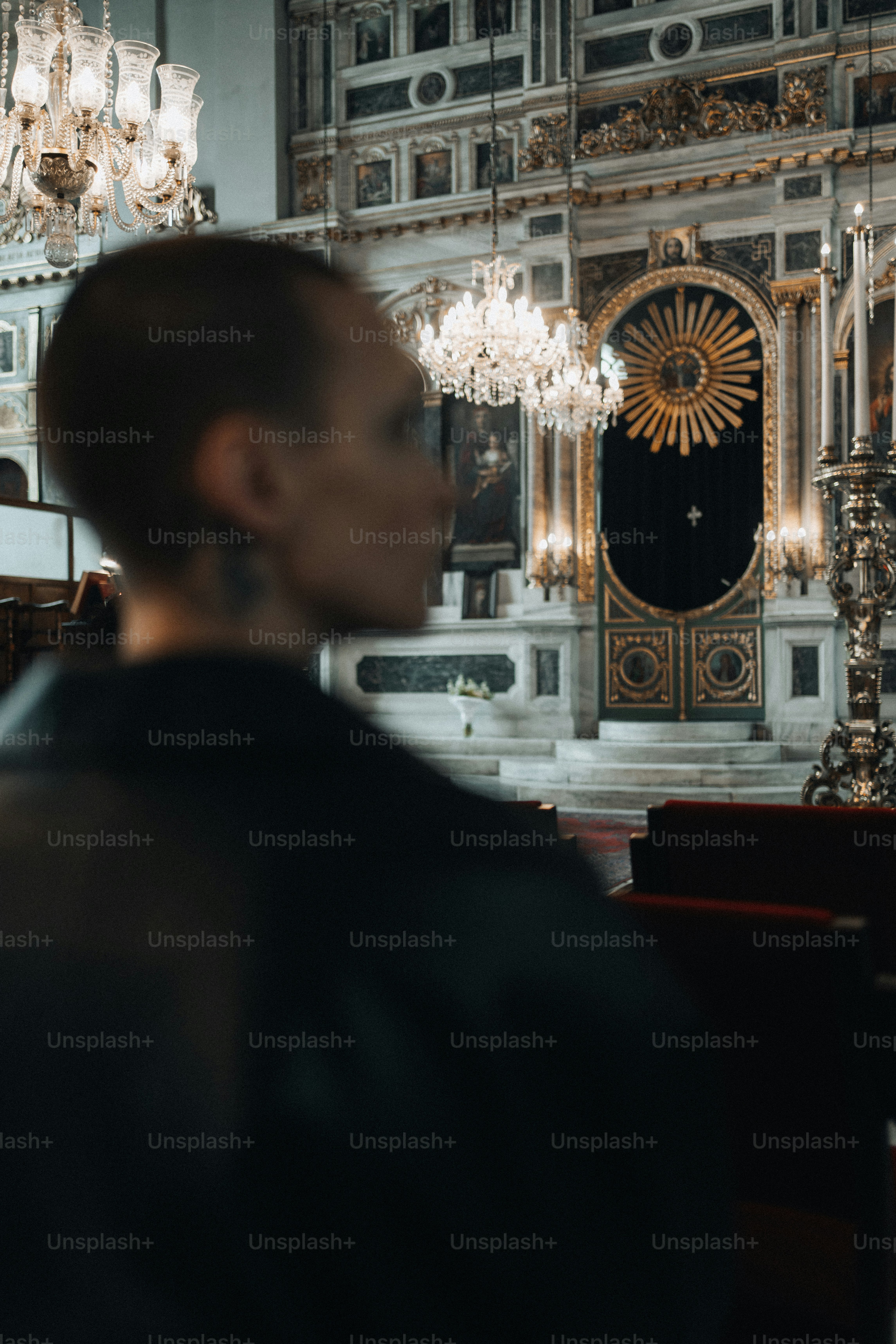 um homem em pé na frente de um lustre em uma igreja