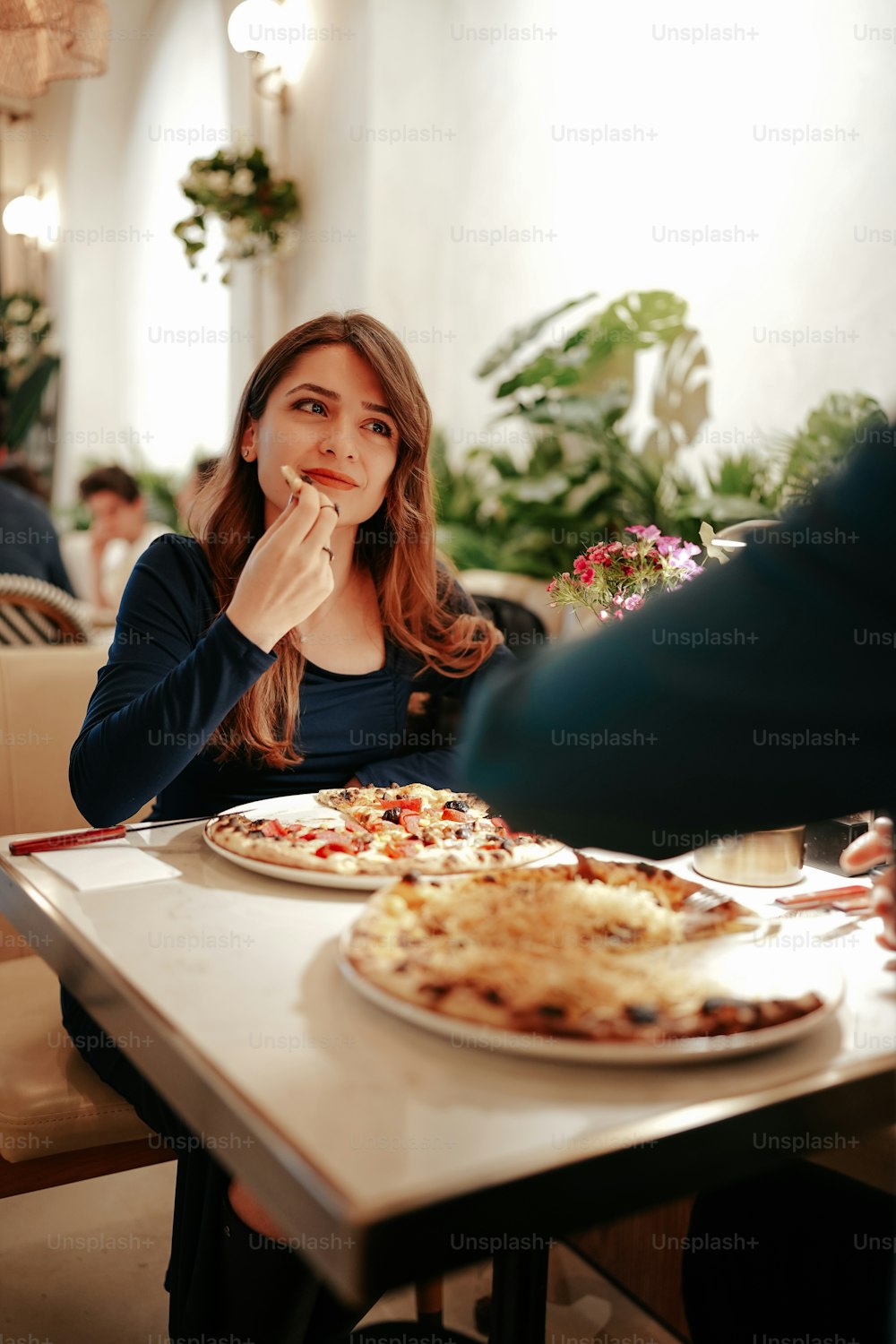 a woman sitting at a table with a plate of food