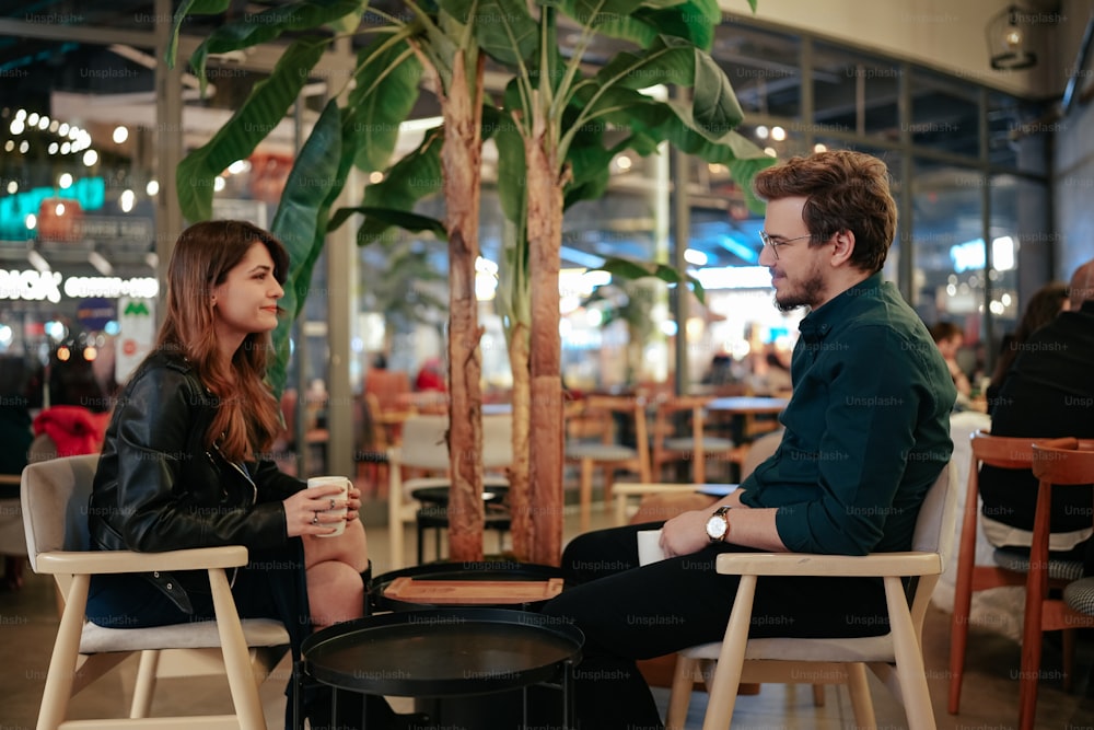um homem e uma mulher sentados em uma mesa conversando