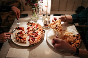 a couple of people sitting at a table eating pizza