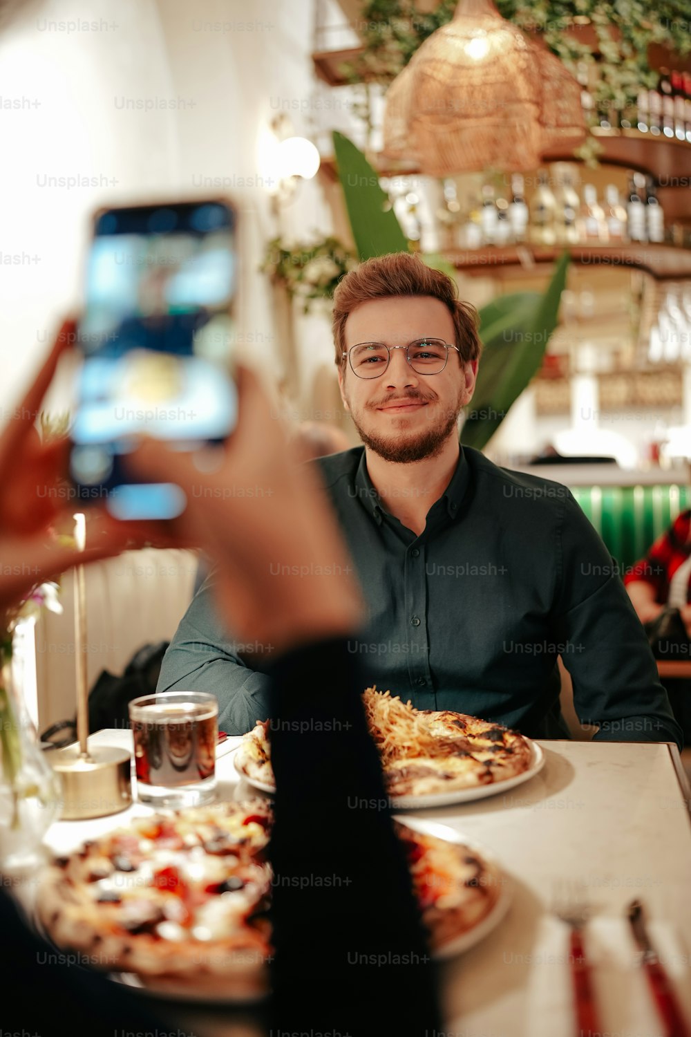 a man sitting at a table with a plate of pizza