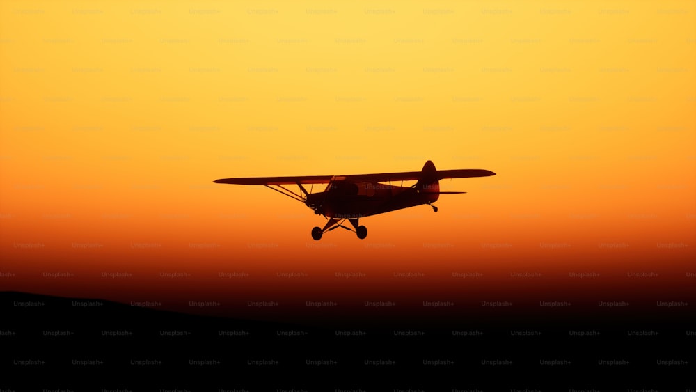 um pequeno avião voando no ar ao pôr do sol