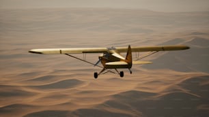 a small airplane flying over a desert landscape