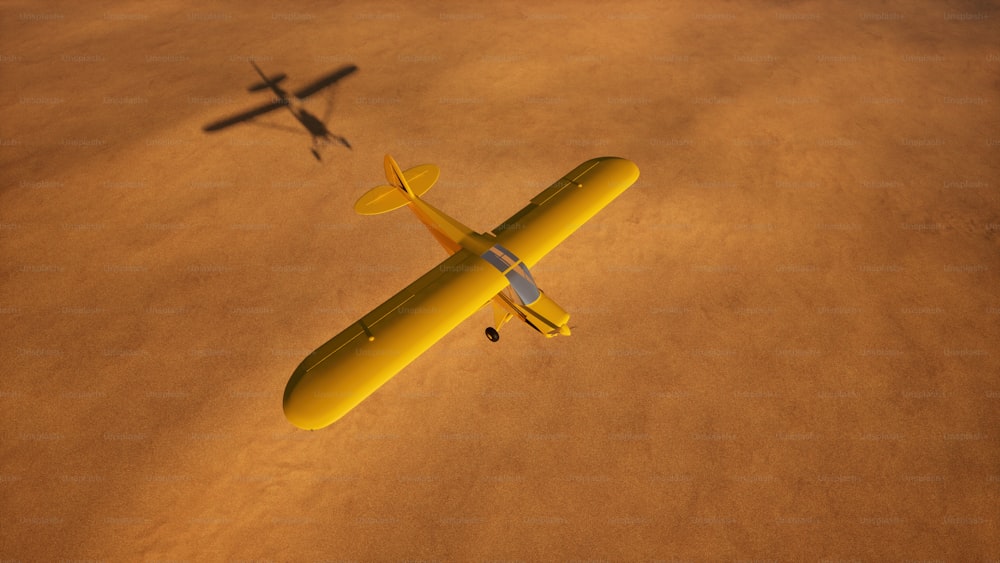 a yellow airplane flying over a sandy area