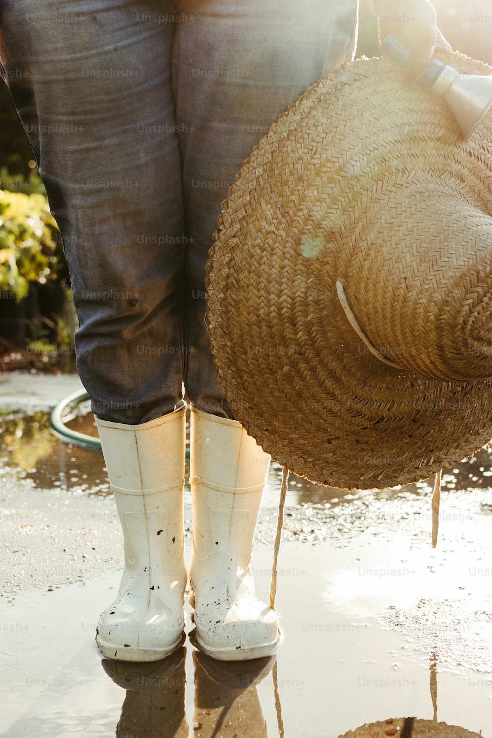 Une femme en bottes blanches en caoutchouc tenant un panier