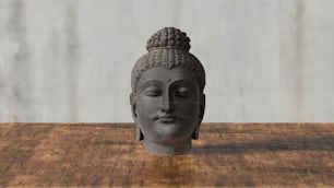 uma cabeça de Buda sentada em cima de uma mesa de madeira