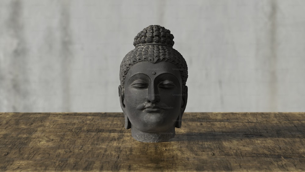 a buddha head sitting on top of a wooden table