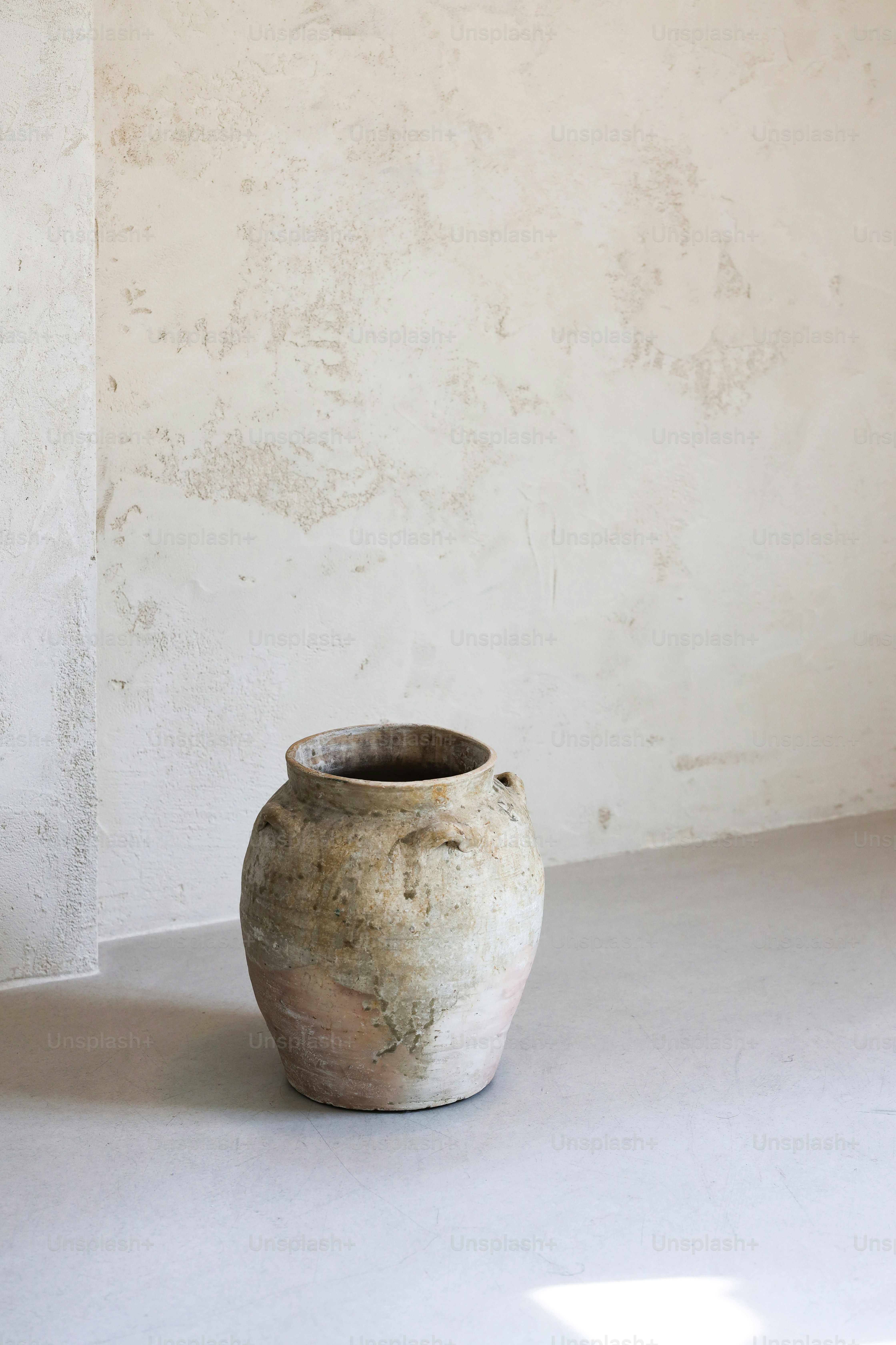 a white vase sitting on top of a white floor