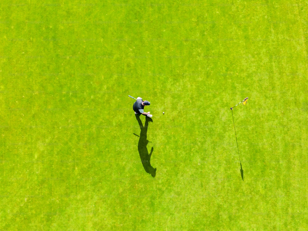 Una vista aerea di un uomo che gioca a golf in un campo verde