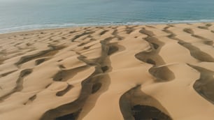 Una spiaggia di sabbia con uno specchio d'acqua sullo sfondo
