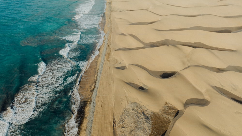 an aerial view of a sandy beach next to the ocean