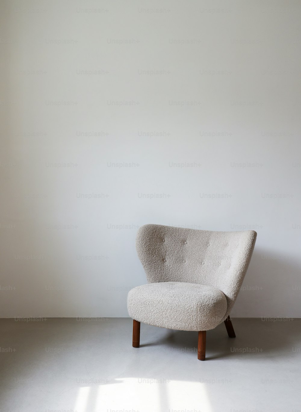 a white chair sitting in a room next to a white wall