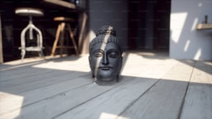 Une statue d’une tête de Bouddha assise sur un plancher en bois