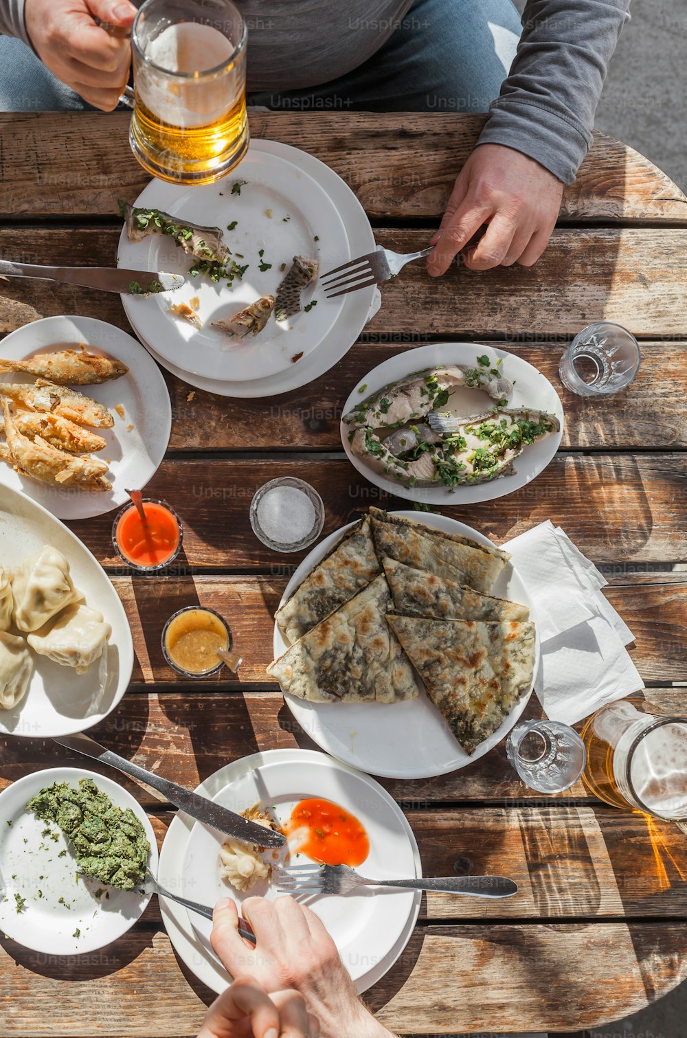 Eine Gruppe von Menschen, die an einem Tisch mit Tellern mit Essen sitzen