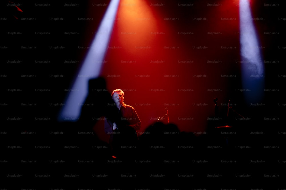 Un uomo in piedi davanti a un microfono su un palco