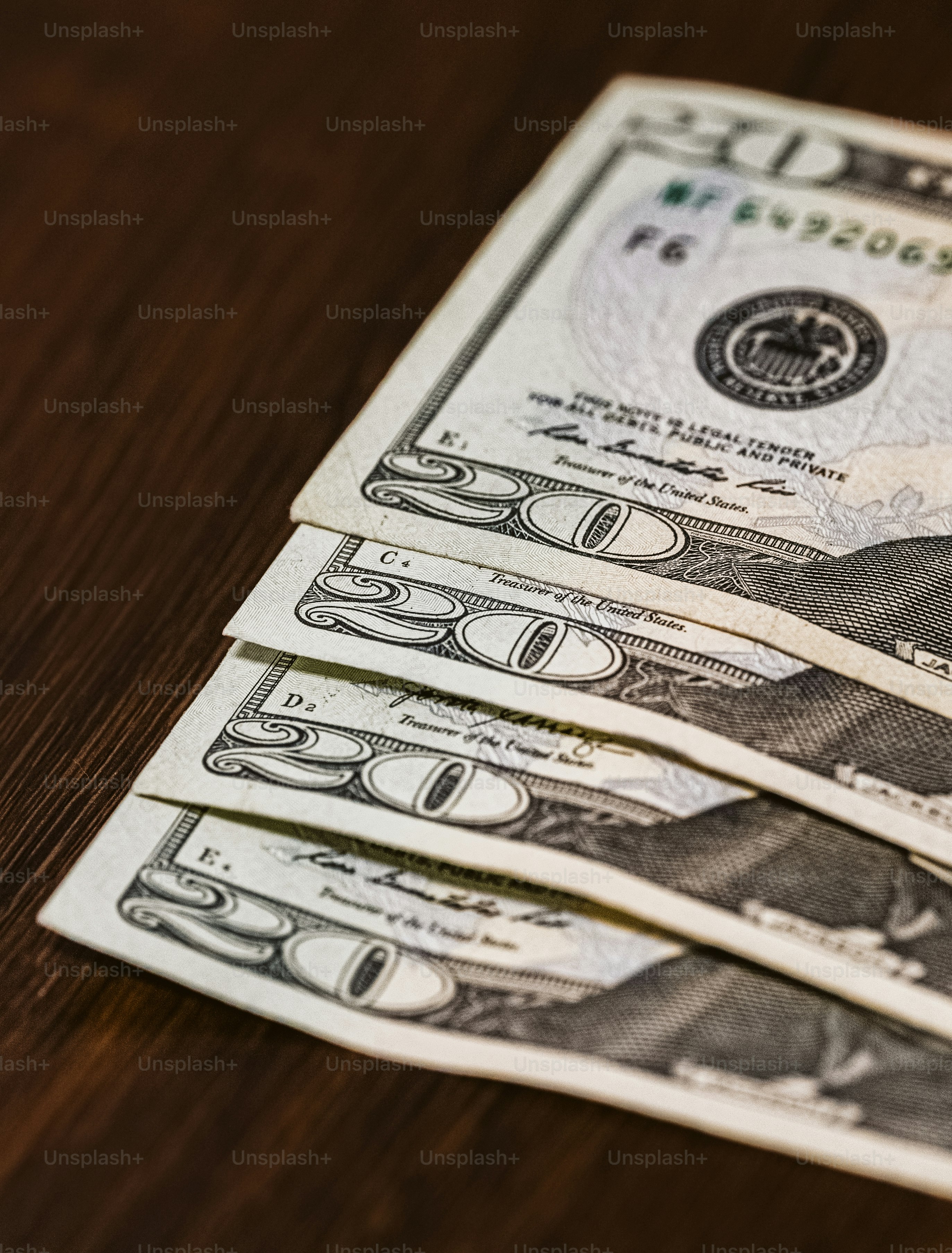 Ein Stapel Zwanzig-Dollar-Scheine, die auf einem Holztisch sitzen