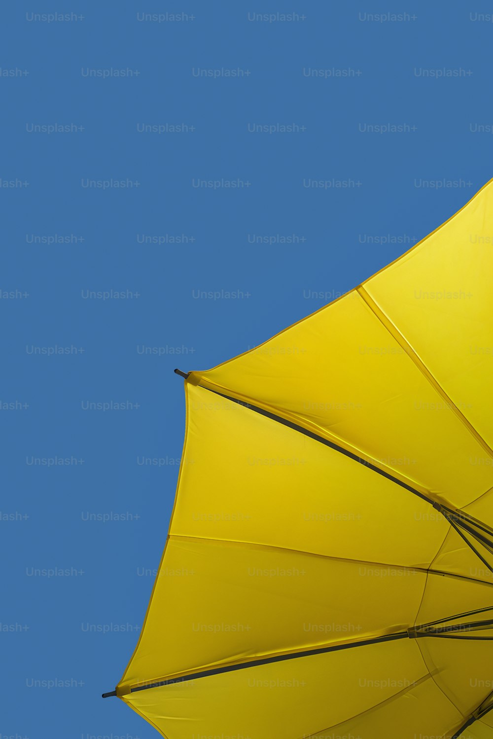 un parapluie jaune avec un ciel bleu en arrière-plan