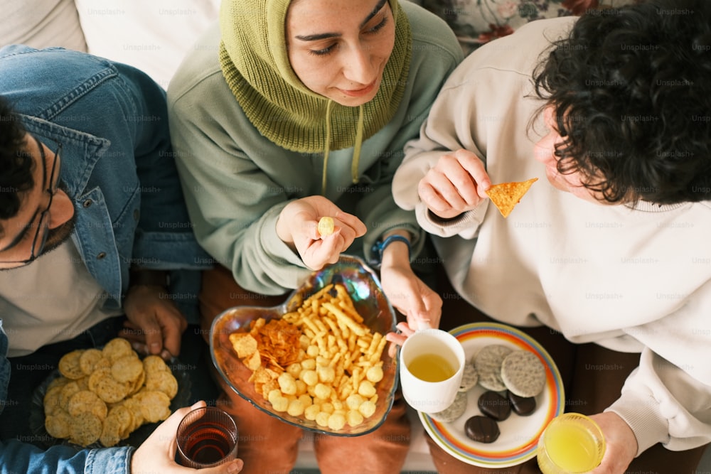 テーブルの周りに座って食べ物を食べる人々のグループ