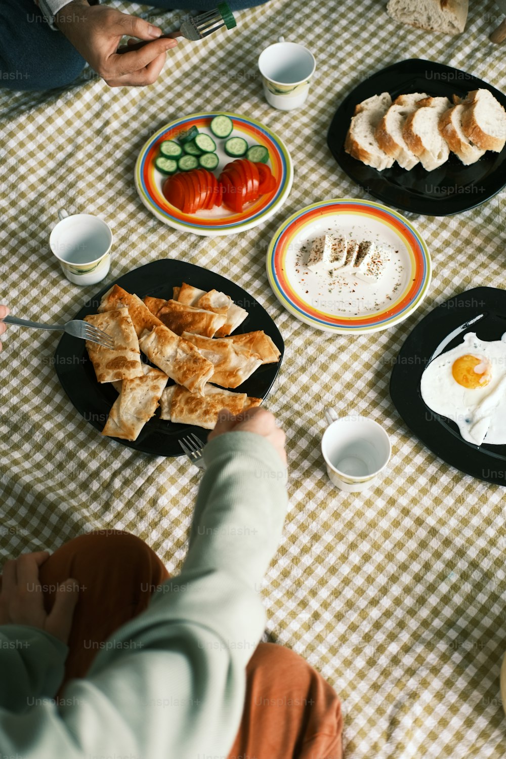 a person sitting at a table with plates of food