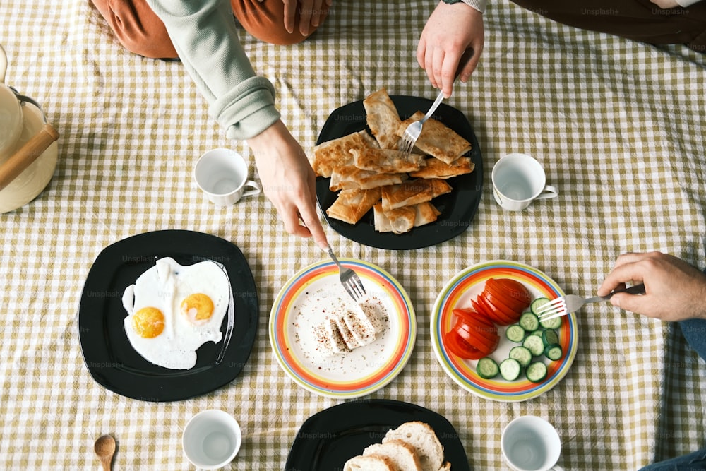 a table topped with plates of food and cups of coffee