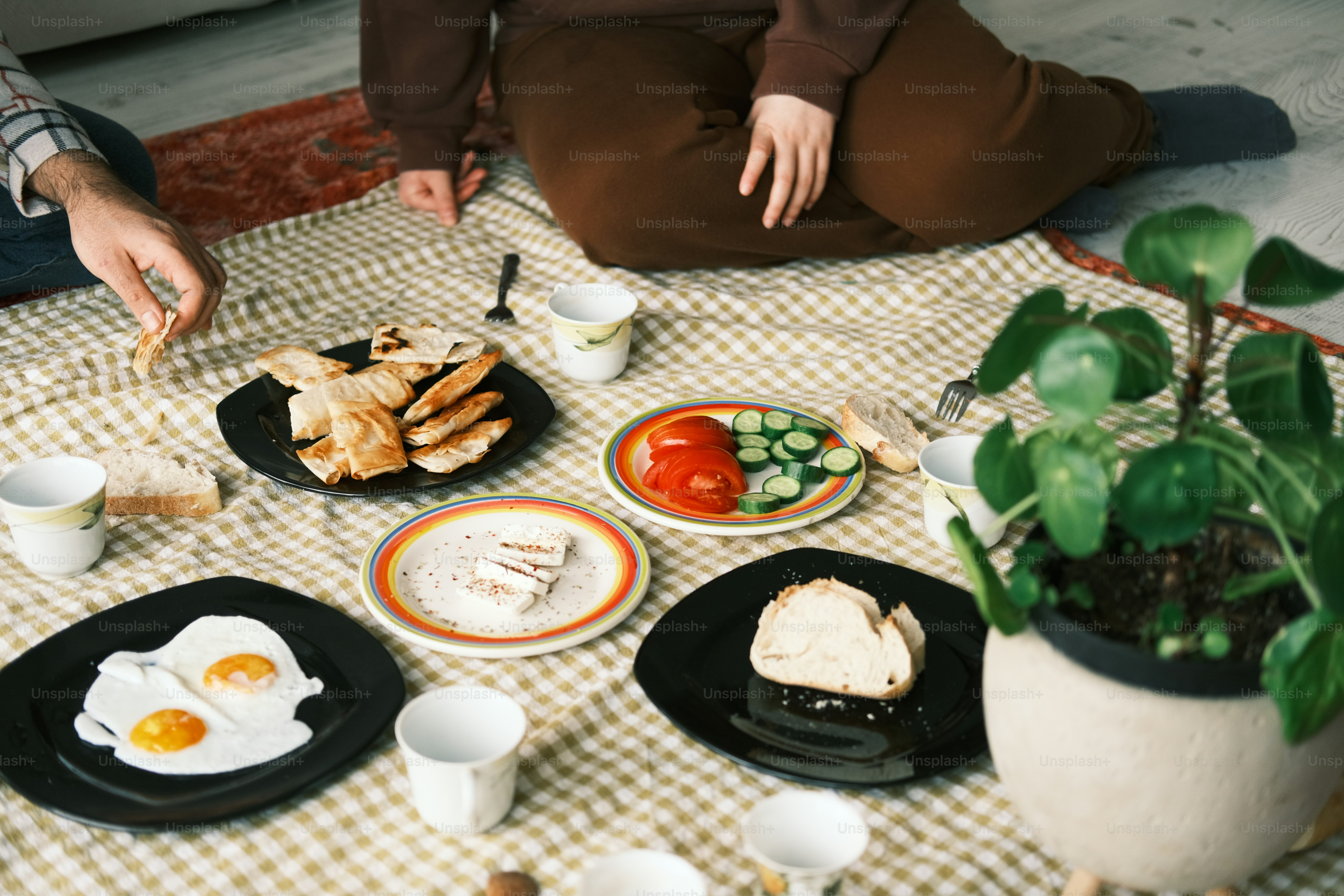 a table topped with plates of food next to a potted plant